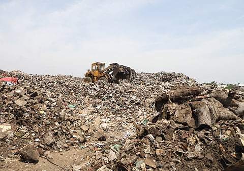 Workers transport legacy waste to the bio-mining facility at the Vellalore dumpyard in Coimbatore.