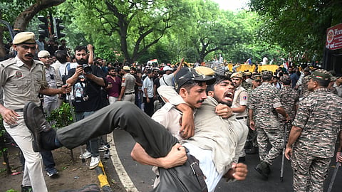 Police personnel detain protesters during the protest march against the alleged NEET paper leak from Jantar Mantar to Parliament House in New Delhi on Monday, July 20, 2026.