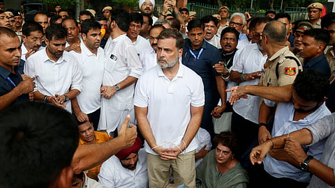 LoP leader Rahul Gandhi, center, with his hands tied, participates in a sit-in protest with his sister and lawmaker Priyanka Gandhi Vadra, center right, outside the residence of Prime Minister Narendra Modi, Tuesday, July 21, 2026.