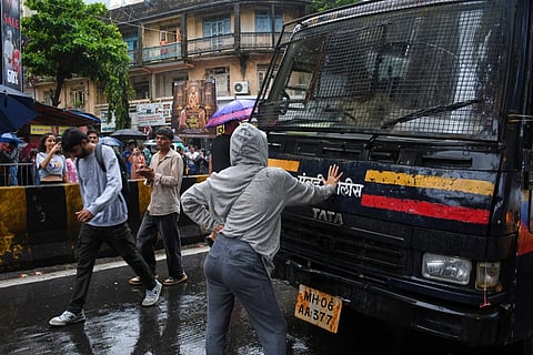 Rhiya Ahir, a model, blocks a police van carrying detained protesters during a demonstration demanding educational reforms as part of the Cockroach Janta Party’s ongoing protest movement in Mumbai, India, Wednesday, July 22, 2026.