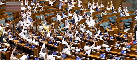 Lok Sabha members raise their hands during the passing of a bill in the House amid the Monsoon session of Parliament, in New Delhi, Monday, July 27, 2026.