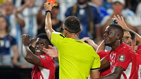 Referee Joao Pinheiro, of Portugal, gives a red card to Switzerland's Breel Embolo (7), left, during the World Cup quarterfinal soccer match between Argentina and Switzerland in Kansas City, Mo., Saturday, July 11, 2026.