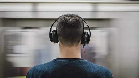 Image of a man listening to music on his headphones used for representational purposes only