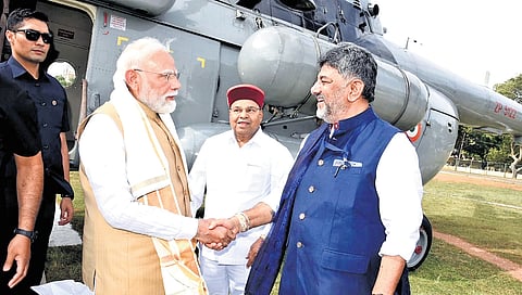 Karnataka CM DK Shivakumar and Governor Thaawarchand Gehlot welcome Prime Minister Narendra Modi in Mysuru on Saturday.