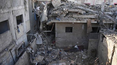 A Palestinian boy stands amid destroyed buildings at the scene of an Israeli airstrike in Nuseirat in the central Gaza Strip, Monday, Aug. 1, 2026.