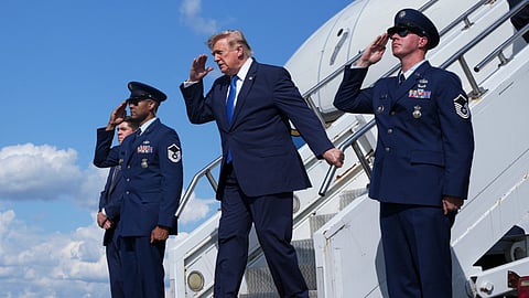 Donald Trump, center, salutes as he exits Air Force One at Morristown Municipal Airport in Morristown, N.J., Friday, July 31, 2026, from Camp David, the presidential retreat.