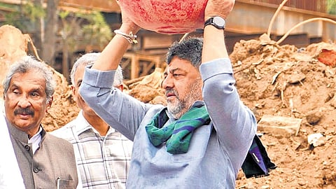 Chief Minister DK Shivakumar carries a tub of mud and debris on his head during the launch of the ‘Freedom from Waste’ campaign in Bengaluru on Saturday.