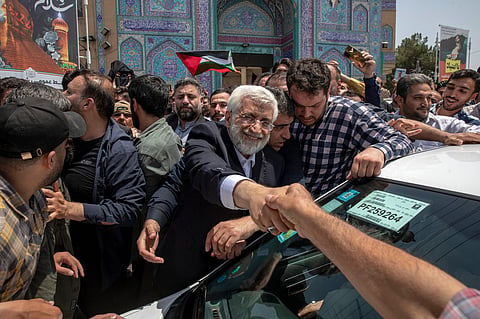 Saeed Jalili, a hard-line former nuclear negotiator, shakes hands with a supporter