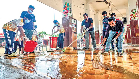 People cleaning the Ranni bus station that was flooded, on Sunday