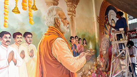 In this photo from July 05, 2026, an artist draws a wall graffiti on the occasion of the upcoming Durga Puja festival on the theme "Prime Minister Narendra Modi offering Puja and prayer at Goddess Durga idol" at Chaltabagan Durga Puja pandal, in Kolkata.