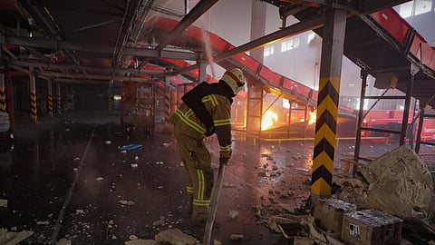 Firefighter put out a fire at a Nova Poshta postal warehouse following Russian air attack on the outskirts of Kharkiv, Ukraine, Sunday, Aug. 2, 2026.