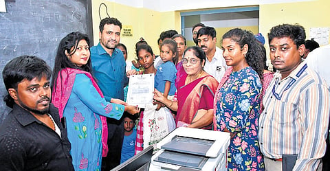 Birth certificate being issued to a child at special camp in Ezhil Nagar