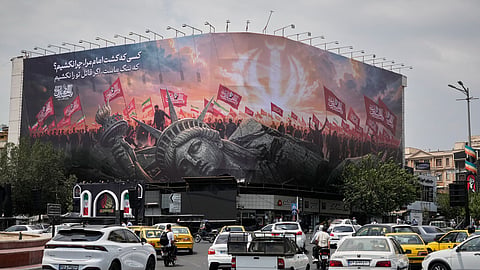 A billboard depicting a fallen Statue of Liberty and crowds carrying Iranian and Shiite flags overlooks Revolution Square as traffic drives by in Tehran, Iran, Monday, Aug. 3, 2026.