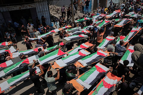 Palestinians carry the flag-draped bodies of members of the Hassayna and Abu Sharia families, who were killed in an Israeli strike in 2023 and whose remains were recently recovered from the rubble, during their funeral in Gaza City, Tuesday, Aug. 4, 2026.