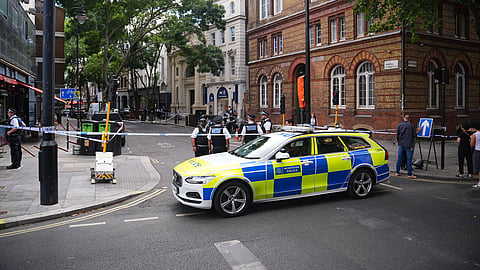 Police officers stand at the scene on Endell Street in Covent Garden, after four men were stabbed, in central London, Wednesday Aug. 5, 2026.