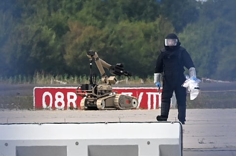 A forensic technician works alongside a bomb-disposal robot near a Ukrainian aircraft at Leipzig/Halle Airport, where a drone with an explosive device was found and a detonator was removed from the object, in Schkeuditz, Germany, Wednesday Aug. 5, 2026.