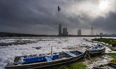 Boats lie along the banks of Yamuna river as a thick layer of toxic foam floats on the water during monsoon, at Kalindi Kunj, in Okhla