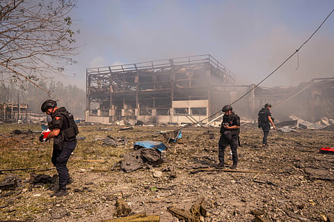 Police officers inspect the area, after a Russian attack struck a warehouse, followed by an explosion, in the village of Myla, Kyiv region, Ukraine, Saturday, Aug. 29, 2026.