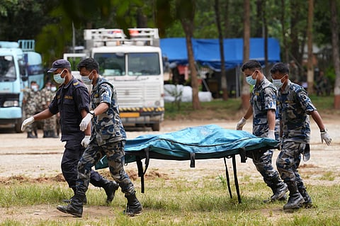 Armed Police Force personnel carry a body bag to be brought on a helicopter at a helipad in army camp in Trishuli, Nuwakot district, Nepal, Sunday, Aug. 30, 2026.