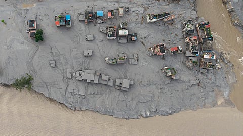 An aerial view shows houses lying deluged in sludge after flash floods at Devighat, Bidur Municipality, along the confluence of the Trishuli and Tadi rivers in Nepal's Nuwakot district on August 27, 2026.