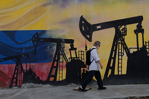 A pedestrian walks past a mural featuring oil wells in Caracas, Venezuela, Saturday, Aug 29, 2026, a day after President Donald Trump announced a deal giving the United States a stake in Venezuela’s oil reserves.