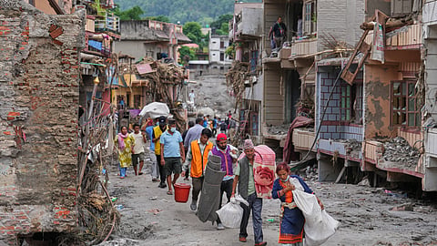 Residents carry their belongings salvaged from their damaged homes filled with mud and debris in Devighat, in Nepal's Nuwakot district, Saturday, Aug. 29, 2026, following the Aug. 26 flash floods.