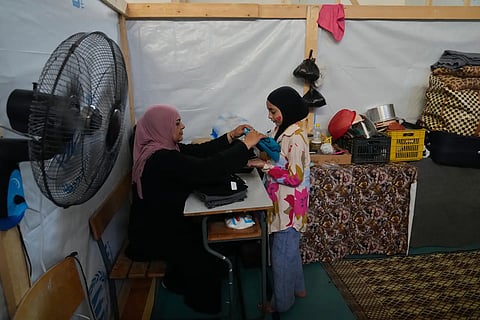 Displaced Randa al-Taki, 51, and her daughter Fatima Khashab, 11, arrange their clothes inside a makeshift room that was set on a basketball court inside a public school turned into a shelter for people whose villages in southern Lebanon were destroyed or occupied by Israeli forces, in Tyre, southern Lebanon, Thursday, Aug. 27, 2026.