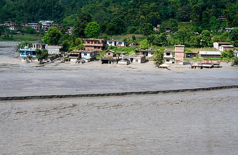 Floodwater and debris inundate a residential area after flash floods, at Belkotgadhi in Nuwakot, Nepal, Sunday, Aug. 30, 2026.