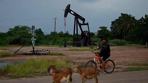 A man rides past an operating oil pumpjack in Cabimas, Venezuela, Monday, Aug. 31, 2026.