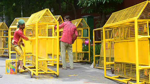 Workers busy in painting police barricades near Barakhamba Road on Tuesday as a part of the beautification drive ahead of the BRICS summit.