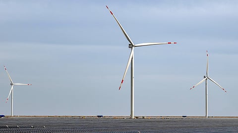 A vast solar power array with wind turbines at a renewable energy facility in Kutch, Gujarat.