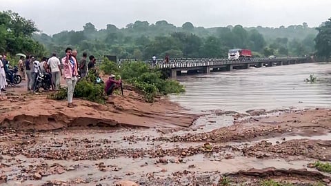 In this photo from Sep. 01, 2026, people stand near a swept-away road after the water level of the Mandakini River rises due to continuous heavy rainfall in Chitrakoot.