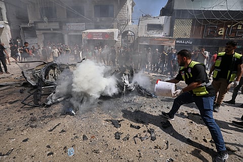 A Palestinian paramedic throws water onto the smoldering wreckage of a car after an Israeli strike in Gaza City, Monday, Aug. 31, 2026.