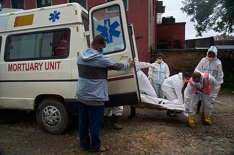 Nepal police officers prepare to load the bodies of flash flood victims for transport from a morgue for mass burial in Kathmandu, Nepal, Tuesday, Sept. 1, 2026.