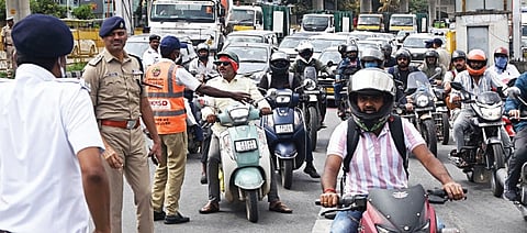 Traffic police personnel divert two-wheeler riders from the KIA road flyover on Friday