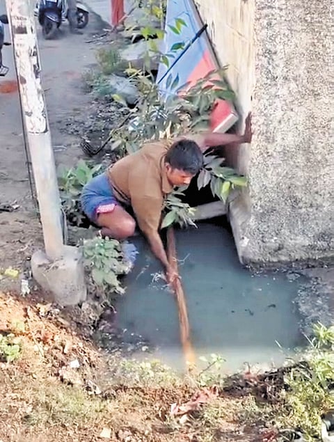 Screengrab from a video showing a sanitary worker cleaning a drain in Vilangudi, Madurai