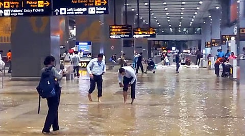 Staff inspecting waterlogging condition at the Indira Gandhi International Airport after heavy rainfall in New Delhi.