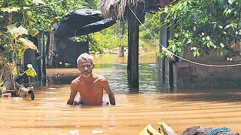 A man wades through waist-deep floodwaters in Pattamundai block.
