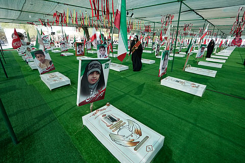 A woman walks at the graveyard of the school children who were killed after their school was a hit by a strike on Feb. 28, in town of Minab in southern Iran, Saturday, Sept. 5, 2026.