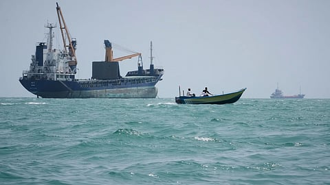 A motorboat passes a general cargo ship anchored in the Strait of Hormuz off Bandar Abbas, Iran, Sunday, Sept. 6, 2026.