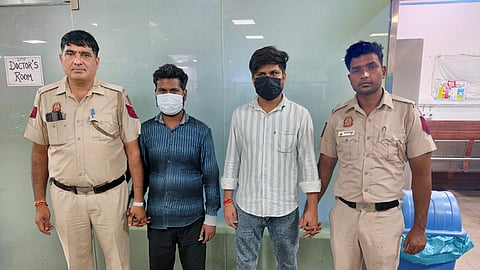 Delhi Police personnel stand with paying guest (PG) operator Sudhanshu, second right, and labor contractor Sanoj, following their arrest in connection with the Satya Niketan building collapse case, in New Delhi.