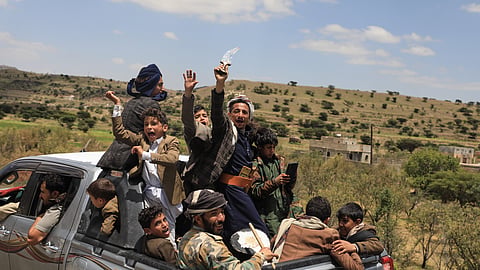Yemeni civilians celebrate while riding in the back of a pickup truck in the Bani Matar district, Yemen, Saturday, Sept. 12, 2026, as they follow a convoy carrying Houthi prisoners freed in Mokha on its way to Sanaa following the Houthi takeover of the southern Red Sea port city.