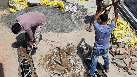 Municipal Corporation of Delhi (MCD) workers break concrete slabs on a rooftop of a PG during a demolition drive against illegal construction in Laxmi Nagar, in New Delhi on Wednesday.