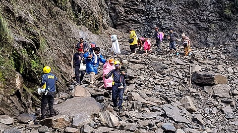 SDRF personnel evacuate stranded pilgrims after debris and stones temporarily closed the Kedarnath Yatra trekking route near Chirbasa helipad, in Rudraprayag, Uttarakhand, Monday, Sept. 14, 2026