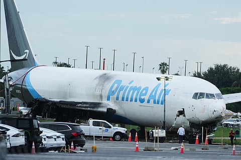 Workers inspect an Amazon cargo plane that overshot a runway four days ago at Miami International Airport, Thursday, Sept. 10, 2026, in Miami.