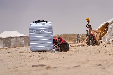 Displaced Yemenis collect water at Al-Firdaws camp in Ras Imran, just outside Aden, Yemen, Monday, Sept. 14, 2026.