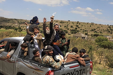 Yemeni civilians celebrate while riding in the back of a pickup truck in the Bani Matar district, Yemen, Saturday, Sept. 12, 2026, as they follow a convoy carrying Houthi prisoners freed in Mokha on its way to Sanaa following the Houthi takeover of the southern Red Sea port city.