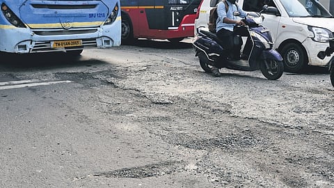 A pothole-laden stretch near Vijayanagar bus stand in Velachery.