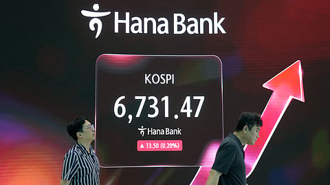 Currency traders pass by a screen showing the Korea Composite Stock Price Index (KOSPI) at the foreign exchange dealing room of the Hana Bank headquarters in Seoul, South Korea, Thursday, Sept. 17, 2026.