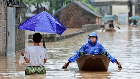 Local residents commute by boat through a flooded village on the outskirts of Hanoi, Vietnam Thursday, Sep. 17, 2026.